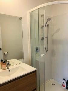 een badkamer met een glazen douche en een wastafel bij Cozy Brand New Townhouse 26 in Auckland