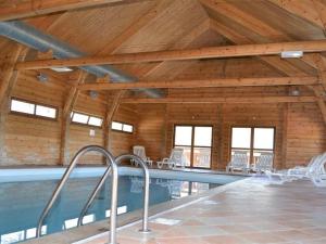 德沃吕伊Chalet confortable La Joue du Loup, piscine - FR-1-504-638的一座带木制天花板的建筑中的游泳池