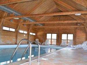 a swimming pool in a building with a wooden ceiling at Chalet La Joue du Loup, 3 pièces, 6 personnes - FR-1-504-638 in Le Dévoluy