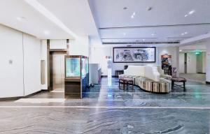 a large lobby with a couch and a fish tank at Paco Hotel Tianhe Couch Terminal Metro Guangzhou in Guangzhou