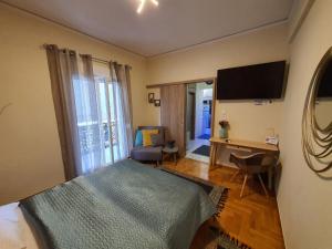Schlafzimmer mit einem Bett, einem Schreibtisch und einem TV in der Unterkunft Cozy Little Home in Athen