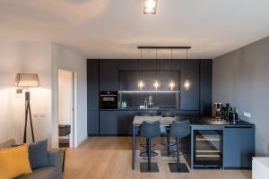 a kitchen with black cabinets and a table and chairs at MAAN BZ15 Luxury Apartment in Zadar