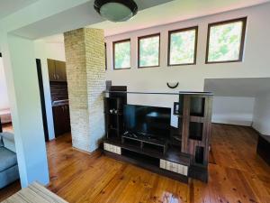 a living room with a large flat screen tv at Къща за гости Под Манастира in Skrino +17 photos