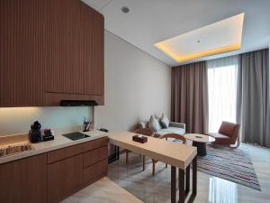 a kitchen and a living room with a table at Ra Suites Simatupang in Jakarta