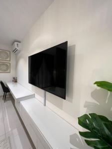 TV de pantalla plana en una pared blanca en The Lennox Luxury Apartment, en Accra