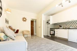 a white living room with a white couch and a kitchen at Beachome4u in Carcavelos