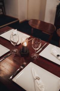 a wooden table with a candle and glasses on it at Hotel Tunneli in Sastamala +20 photos