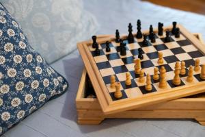 索卡的住宿－Bovec Home At Three Samoyeds，枕头旁边的桌子上放着木象棋