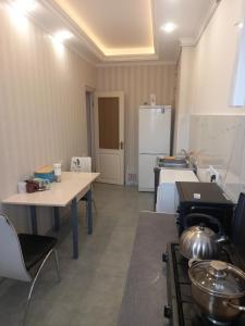 a kitchen with two tables and a refrigerator at Malacia apartments in Yerevan