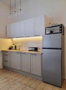 a kitchen with white cabinets and a refrigerator at Apartament Za Murami Gliwice in Gliwice