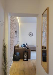 sala de estar con sofá y pared de ladrillo en Apartament Za Murami Gliwice, en Gliwice