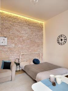 a bedroom with a bed and a brick wall at Apartament Za Murami Gliwice in Gliwice