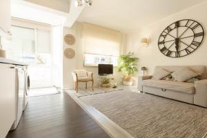 a living room with a couch and a clock on the wall at Beachome4u in Carcavelos