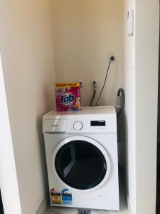 uma máquina de lavar roupa com uma caixa em cima em Cozy Brand New Townhouse 27 em Auckland