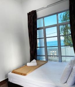 a bedroom with a bed with a large window at Raihan Beach Resort in Dungun +171 photos