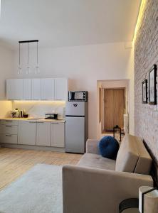 a living room with a couch and a kitchen at Apartament Za Murami Gliwice in Gliwice