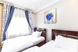 2 camas en una habitación con ventana en Willington Haven, en Kampala