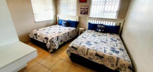 a bedroom with two beds with blue and white sheets at La Mer 12 - 9 Sleeper - Stylish & Sophisticated! in Margate +12 photos