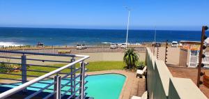 a swimming pool with the ocean in the background at La Mer 12 - 9 Sleeper - Stylish & Sophisticated! in Margate