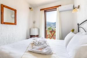 a bedroom with a bed with a mirror and a window at Amalia2 in Skopelos Town