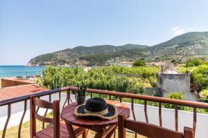 a hat sitting on a table on a balcony overlooking the ocean at Amalia2 in Skopelos Town +33 photos