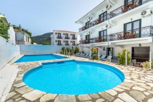 a swimming pool in the middle of a courtyard with a building at Amalia2 in Skopelos Town