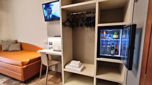 a small room with a refrigerator with a table and a desk at Valmarina in Calenzano