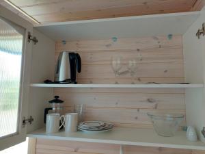 a kitchen with two wine glasses on a shelf at Päikesemajake 2 in Soonlepa