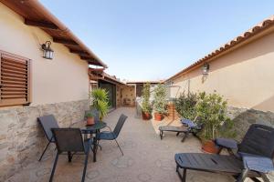 un patio con sedie, tavoli e una parete di Casa Las Toscas a Ingenio