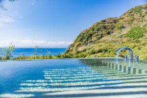 a swimming pool with a view of the ocean at WEAZER 西伊豆 in Izu