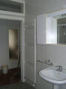 a white bathroom with a sink and a mirror at PIETRAMURATA APPARTAMENTO VISTA MONTAGNA terzo piano in Dro