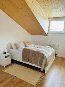 1 dormitorio con 1 cama con techo de madera en V ulicke, en Kežmarok