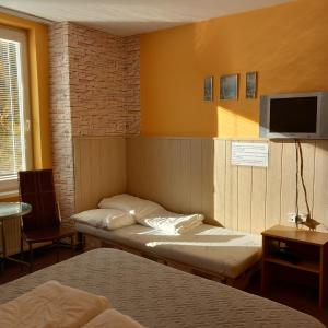 um quarto com 2 camas e uma televisão de ecrã plano em Privát Čujová em Hrabušice