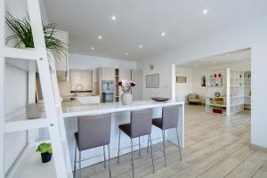 a kitchen and living room with a counter and chairs at Stylish 3 Bedroom Holiday Apartment in St Julians in St Julian's