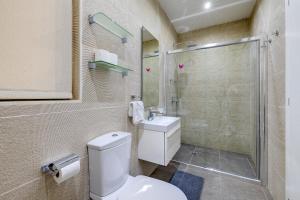 a bathroom with a toilet and a shower and a sink at Stylish 3 Bedroom Holiday Apartment in St Julians in St Julian's +30 photos