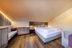 ein großes Schlafzimmer mit einem großen Bett und einem Sofa in der Unterkunft PEOPLE'S Hotel in Kaprun