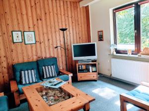 Una sala de estar con una mesa y un televisor. en Ferienwohnung Grueßing, 15014, en Leer