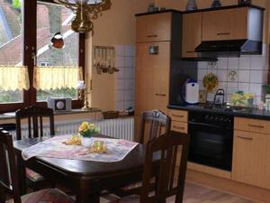 Una cocina con una mesa con sillas y una estufa. en Ferienwohnung Grueßing, 15014, en Leer 14 fotos más