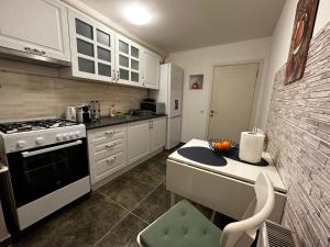 a kitchen with white cabinets and a stove top oven at Terrace apartments otopeni ! in Otopeni