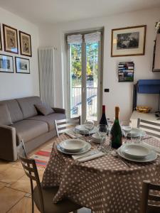 - un salon doté d'une table avec des assiettes et des verres à vin dans l'établissement Residence Belvedere Apartment Volesio, à Tremezzo