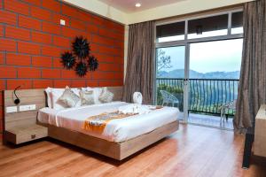 a bedroom with a bed with an orange wall at Serene Crest Resort in Mananthavady