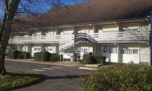 a building with a white staircase in front of it at Campanile Hotel Chantilly in Chantilly