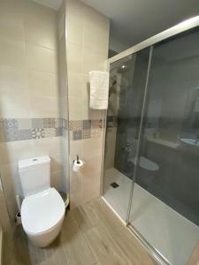 een badkamer met een toilet en een glazen douche bij III Apartamento junto a PLAZA MAYOR in Salamanca