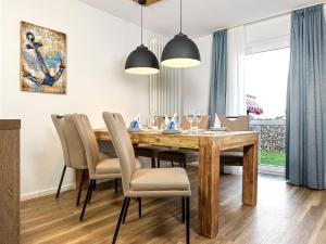 a dining room with a wooden table and chairs at Haus Südwester Herzmuschel in Timmendorf