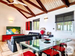 a living room with a glass table and a couch at Les Balcons du sud - Villa Perle de l'Océan - 180 m2 avec piscine - Les Avirons in Les Avirons