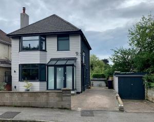 uma casa branca com janelas pretas e uma garagem em Modern 3 Bedroom Home in Coy Pond, Poole em Parkstone