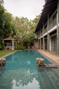 a swimming pool with an elephant statue in the water at 41 Lighthouse Street in Galle