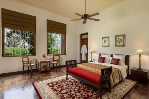 a bedroom with a bed and a table and chairs at Jetwing Uva Ben Head Villa in Welimada