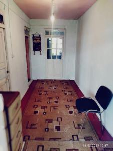 een lege kamer met twee stoelen en een deur bij Buuzara Guest House in Batken