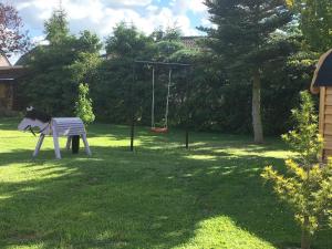 um parque infantil com um baloiço num quintal em Bungalow Arelt em Mesekenhagen